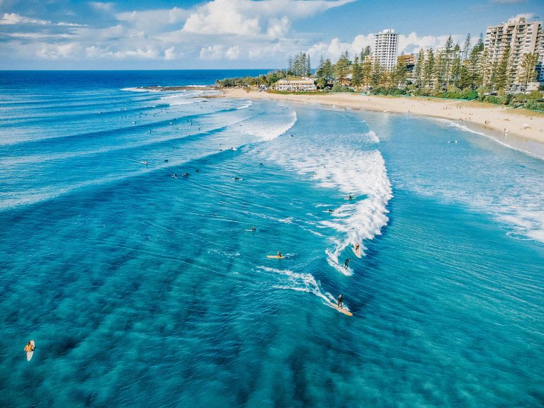 Point break with clean groundswell coming in and surfers riding on waves